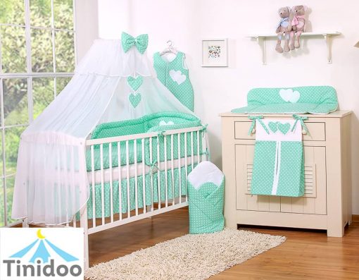 lit bébé avec linge de lit vert